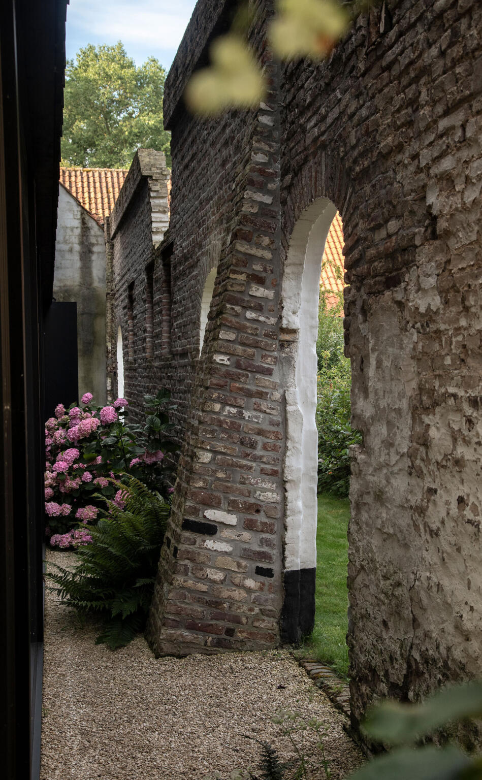 Greenarchitects stefaan willems landschapsarchitect afsnee grindpad met hortensia varens en historische muur