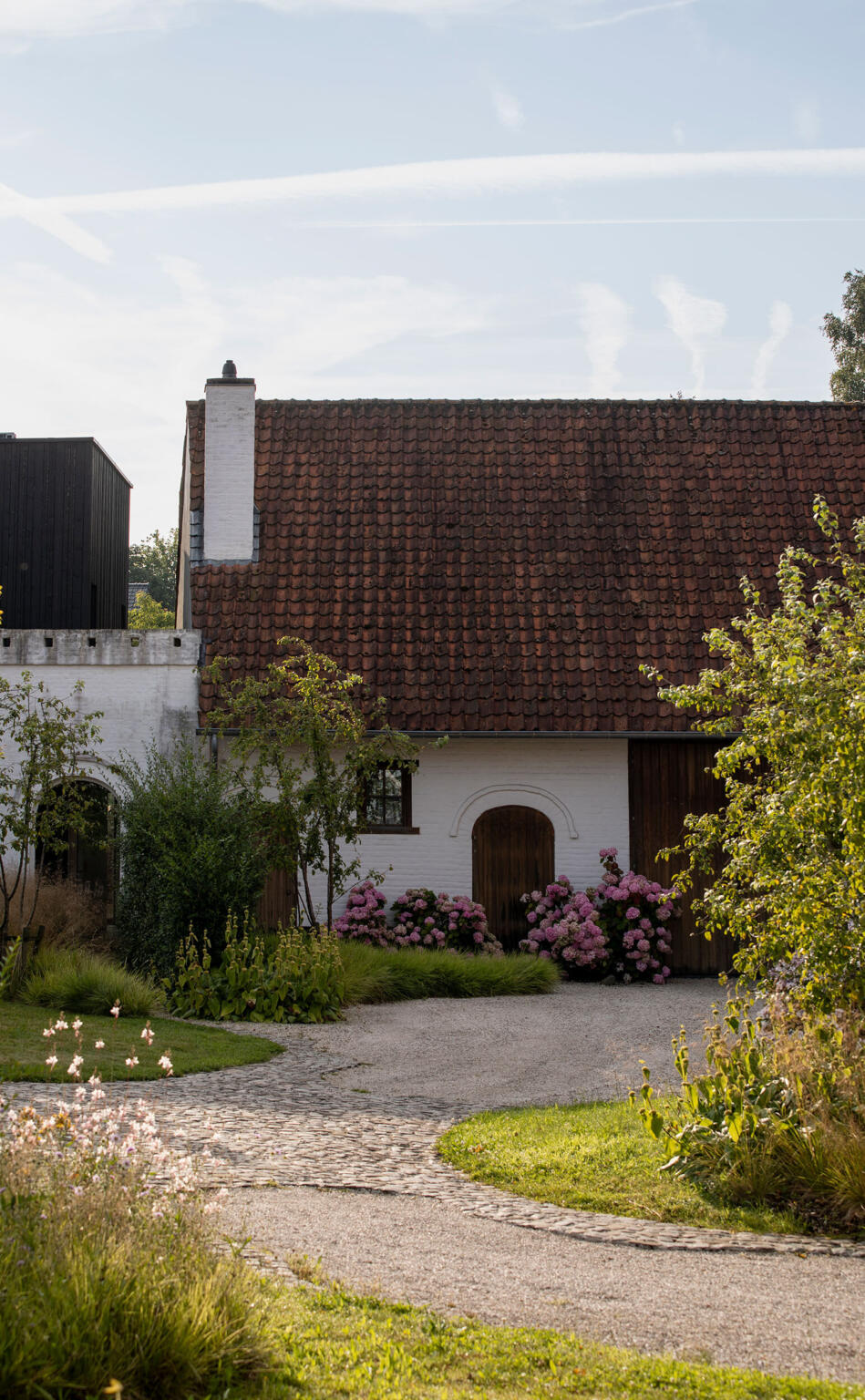 Greenarchitects stefaan willems landschapsarchitect afsnee kasseienpad met hortensia gaura phlomis en historische gevel