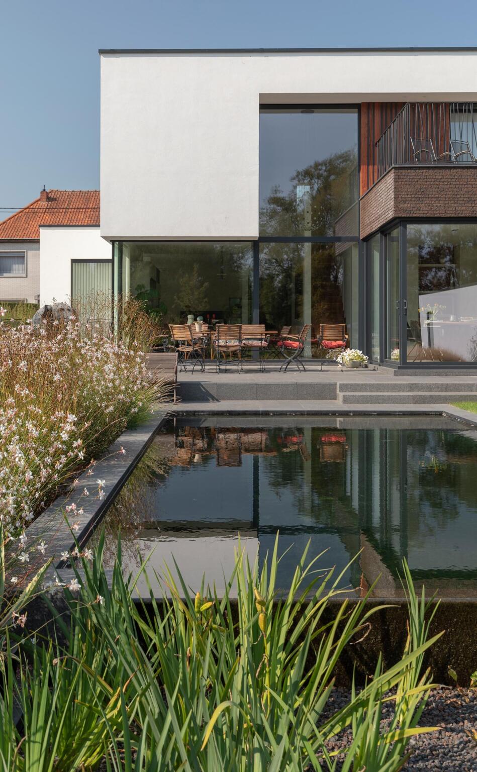 Greenarchitects stefaan willems tuinarchitect ninove moderne woning zwemvijver filterbak lavasteen terras tegels natuursteen gaura sesleria vlinder bijen 01